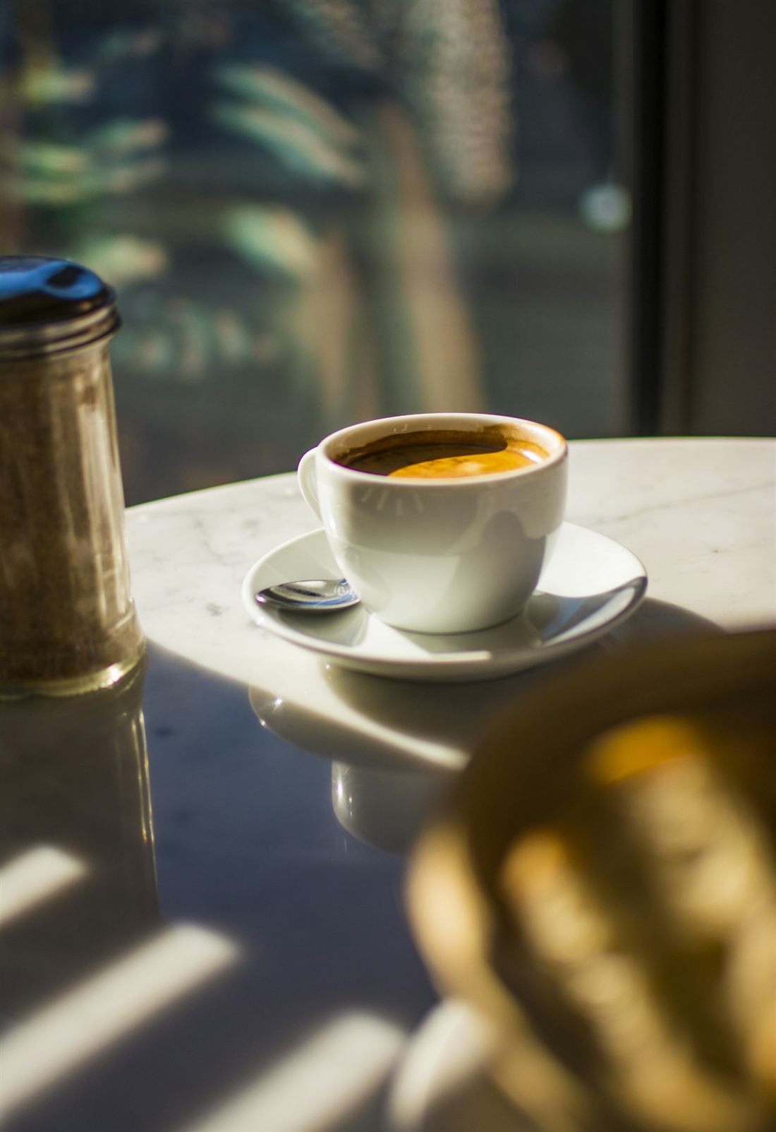 Une tasse de café posée sur une table, baignée de soleil